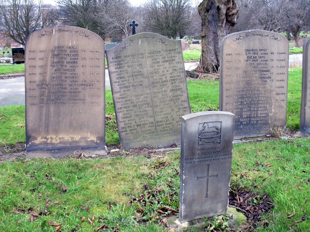 The front one is inscribed 'S908 Private J. Denison, West Yorkshire Regiment, 3rd November 1918, age 29.' Behind are three common graves commemorating a number of unrelated people all buried in 1918.