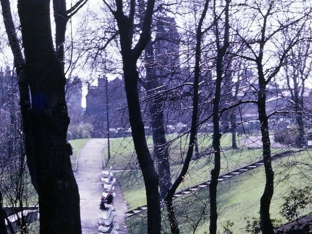 A view from Scarth Gardens along both parts of Scatcherd Park in April 1962 - notice the dome of the Town Hall still missing after the fire of August 1961. The original Scatcherd Park stretched as far as the end of the park benches from the border on Queen's Promenade in the foreground. The section beyond the park benches is an addition to the original park of 1911 and was laid out between 1936 and 1939 in the area that had originally been the grounds of Morley House. This building and its grounds were bequeathed to Morley Town Council in the will of its last owner Mr. Richard Borrough Hopkins, Morley's first town clerk. Strictly speaking this extension to Scatcherd Park is correctly known as the Hopkins Gardens.