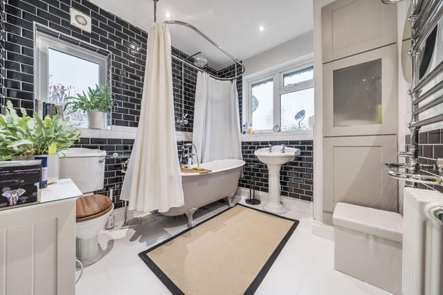 The recently modernised tiled house bathroom has a gorgeous three-piece suite with WC, hand basin and freestanding bathtub, with a further storage area.