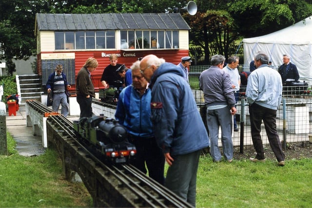 People admire the miniature steam locomotives.
