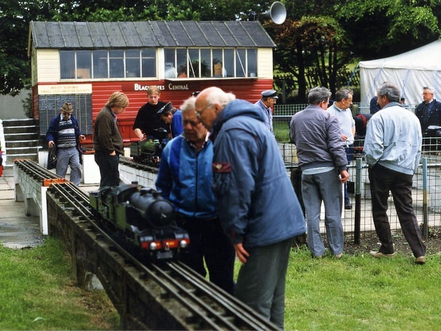People admire the miniature steam locomotives.