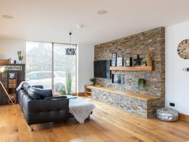 A sitting room with feature wall and inbuilt shelf.