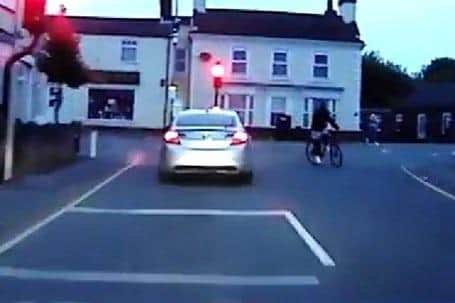 A still from the police dash-cam footage as the driver narrowly misses a cyclist.