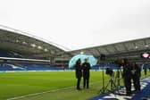 A TV camera crew shelter from the rain prior to a Premier League fixture at Brighton's American Express Community Stadium  (Photo by Bryn Lennon/Getty Images)