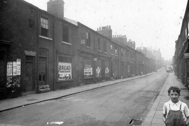 A young boy is pictured in the right foreground of this photo of the south west side of Byron Street, taken from the street corner of the junction with Regent Street, facing uphill to North Street. The photo shows a row of disused shops opposite Mac-Sky Stores and terrace houses.  Pictured in August 1935.