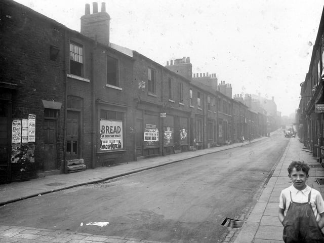 A young boy is pictured in the right foreground of this photo of the south west side of Byron Street, taken from the street corner of the junction with Regent Street, facing uphill to North Street. The photo shows a row of disused shops opposite Mac-Sky Stores and terrace houses.  Pictured in August 1935.
