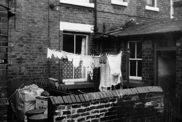 Yarm Place in June 1973. The rear entrances and yards of two through terraced houses on Cambrian Road. The yard of number 28 on the left has been used to store dustbins and other waste while the yard on the right number 30 has clothes hanging on a line visible.