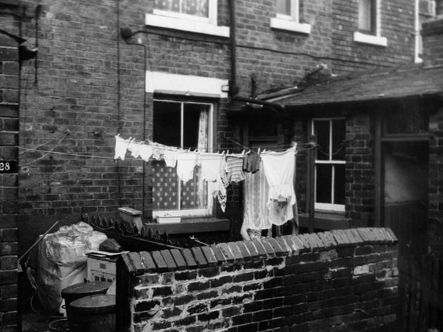 Yarm Place in June 1973. The rear entrances and yards of two through terraced houses on Cambrian Road. The yard of number 28 on the left has been used to store dustbins and other waste while the yard on the right number 30 has clothes hanging on a line visible.