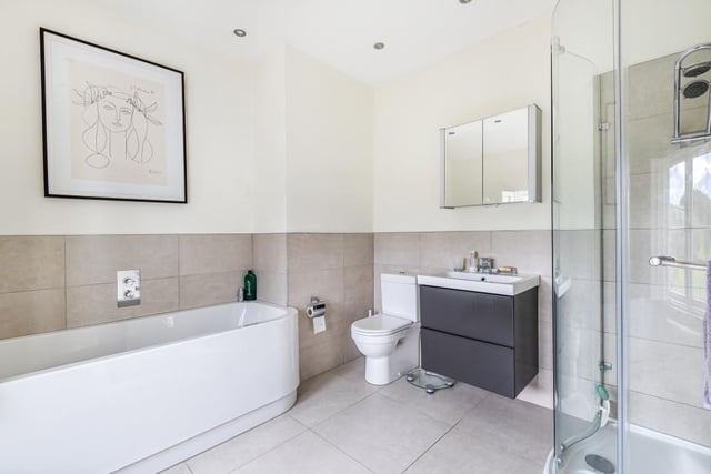 One of the three bathroom facilities, with a suite including bath, separate shower and wash basin with vanity unit surround.