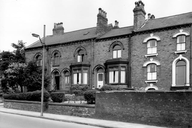 This view shows through properties which faced onto Tong Road. On the left end of the row is number 1 Wesley Road, partially obscured by trees in the garden. Numbers 2 to 6 Southfield Mount follow to right. Numbers 2 and 4 have bay windows. The door of number 4 has an etched glass panel with two striped flowerpots on the top doorstep. Although facing Tong Road, these houses opened onto Southfield Mount to the rear. Pictured in June 1965.