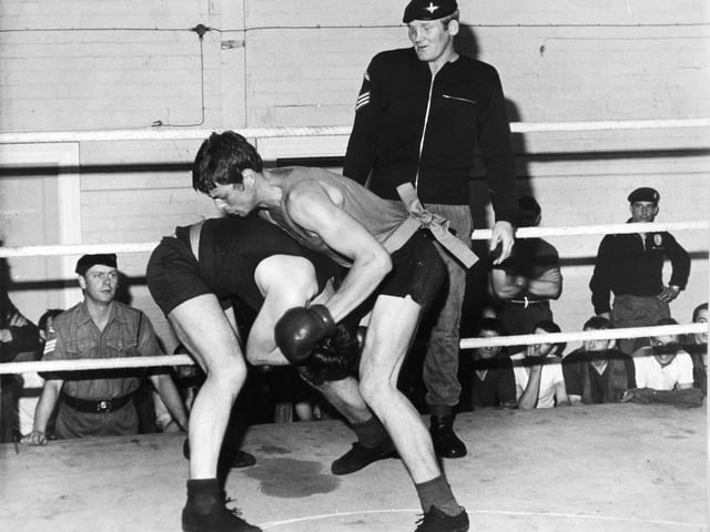 Sergeant Richard Dunn, a parachute regiment contender for the British heavyweight boxing championship, supervises a bout in the ring at Pudsey in September 1975. He beat Bunny Johnson on points over 15 rounds to win the British and Commonwealth heavyweight titles. He unsuccessfully challenged Muhammad Ali for the World Heavyweight title in 1976.