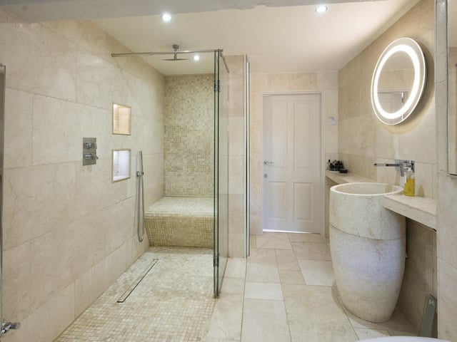 This tiled bathroom has a large, walk in shower facility.