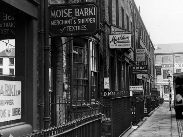 A view looking west along the south west side of York Place in March 1955. To the left is Moise Barki, merchant and shipper of textiles, Markham clothing Co Ltd, H Mackie manufacturing agent, H Kleinman merchants, R Behar merchant shipper, Marston and Hopkinson and Myers Brothers.