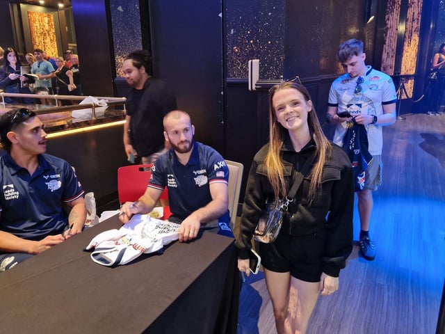 A Rhinos fan with players Keenan Palasia and Jarrod O'Connor.