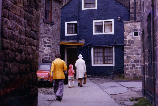A view of old stone built buildings on Bay Horse Court in Otley, with the rear of the Bay Horse pub in the centre. A passageway to the left of the pub leads onto the Market Place.