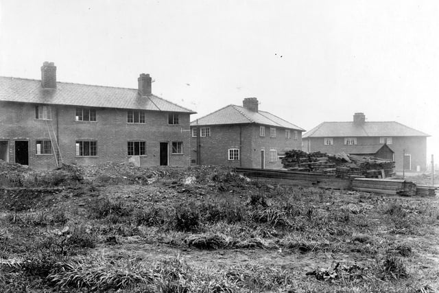 Picture shows the developments to the Wyther Housing Estate. Semi detached houses line the background. Piles of planks are visible to the right. A ladder can be seen leaning up to a window on the left. Pictured in September 1920.
