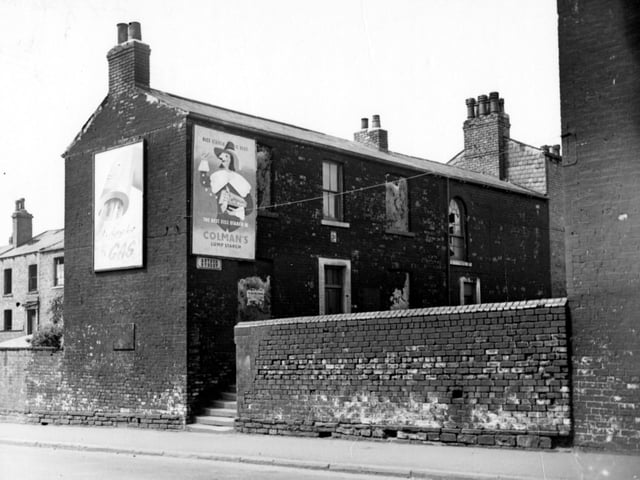 The junction of Arthur Street with Stoney Rock Lane in May 1956. A brick wall blocks the end of Arthur Street except for stone steps providing access. On the end wall is an advertisement for Gas, plus one for Colman's Lump Starch on the row end.