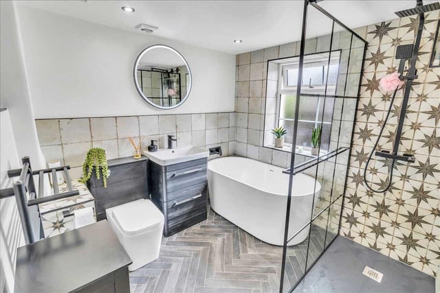 A very modern bathroom with stand alone bath, separate Double Shower with black anthracite fixtures and fittings.