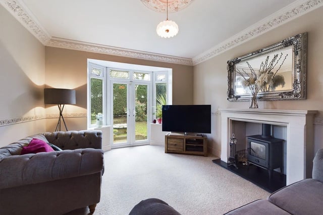 The spacious lounge is equipped with a wood burner, bay windows and doors leading to the garden.