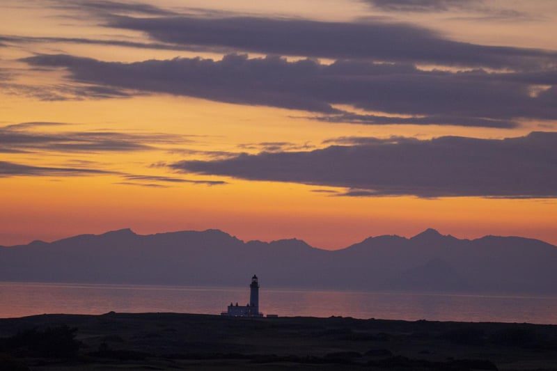 The sun going down behind the Trump Turnberry lighthouse cast dazzling dusk colours over the Ayrshire coast