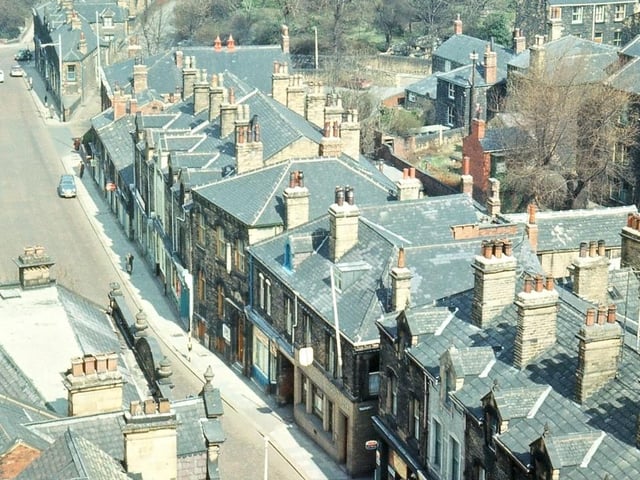 A view northwards along Queen Street from the bell tower of Morley Town Hall. The lack of traffic along the main street is due to the picture being taken on a Sunday morning. Most of the shops, from Ernest Wilson's to before Coffin Corner, date from 1870 to 1890, though the lower, smaller buildings at the end of this parade were probably built at the beginning of the nineteenth century. Pictured in April 1965.