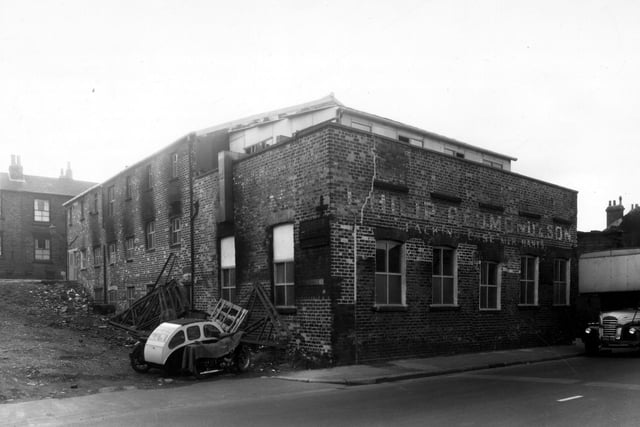 This building number 131A Elland Road was the premises of Philip Redmond and Sons Ltd. They made packing cases, the factory was referred to as a sawmill. Leman Terrace is on the left, looking up to Little Town Lane. It was formerly a malt house used early in the 1900s by the Armley Brewery Ltd. Pictured in September 1960.