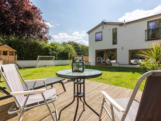 Lawned and landscaped gardens include a decked area and a south-facing, covered sunken terrace.