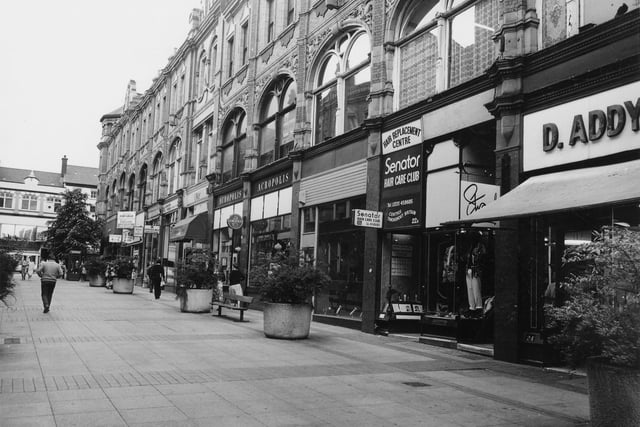 Queen Victoria Street looking in the direction of Briggate. At the right edge is D. Addyman, Pork Butcher at number 24 Queen Victoria Street. The Senator Hair Care Club and Hair Replacememnt Centre is at number 22. Pictured in June 1984.