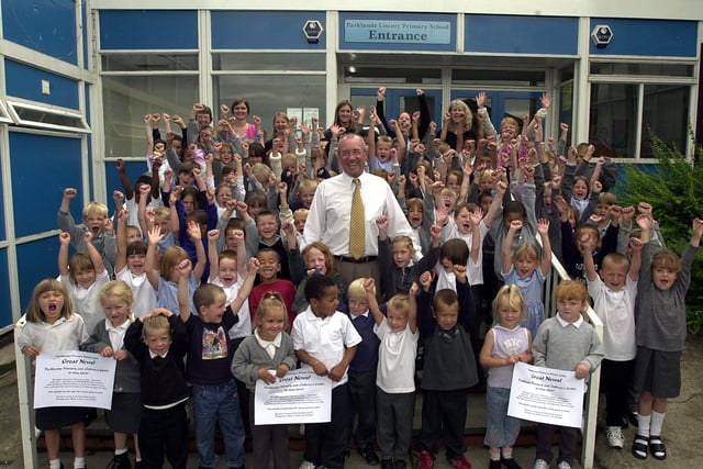 Headteacher Steve Fisher, pictured with some of his cheering pupils and staff, at Parklands Primary School, Seacroft, Leeds, on July 2, 2003.