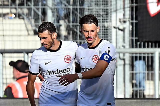 SINSHEIM, GERMANY - OCTOBER 21: Ellyes Skhiri of Eintracht Frankfurt celebrates with Robin Koch of Eintracht Frankfurt after scoring the team's third goal during the Bundesliga match between TSG Hoffenheim and Eintracht Frankfurt at PreZero-Arena on October 21, 2023 in Sinsheim, Germany. (Photo by Markus Gilliar/Getty Images)