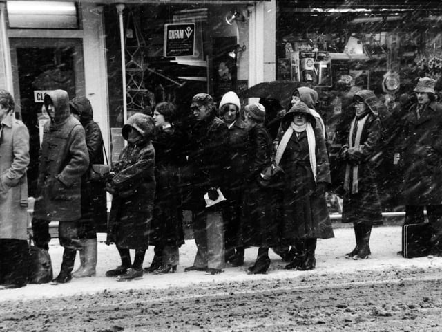 The snow lashes down on shoppers queuing for a bus on Boar Lane as the city evening rush hour begins in February 1979.