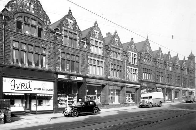 The west side of Chapeltown Road pictured in September 1949. Shops include; The Ivrit Kosher Restaurant; Dobkin's Chemist; Annie Rubin, Poultry Dealer; Abram's Butchers; Capel Stores; Poole's Confectioners; D. Flockton, Electrical Repairs; Harris Tailors and L. Margel, Poultry Dealers. A car and a van are parked on the road, which has tramlines.