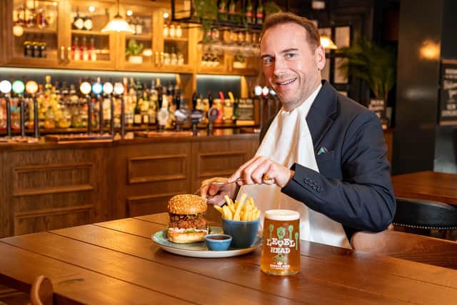 Royal butler eating a burger with a knife and fork