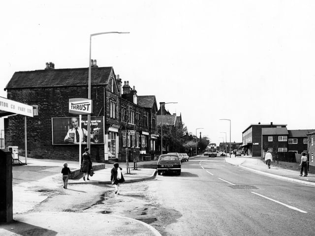Upper Town Street in May 1979. On the left is a garage then a row of shops including Severn Sports. On the right is the junction with Bell Road then another parade of shops.