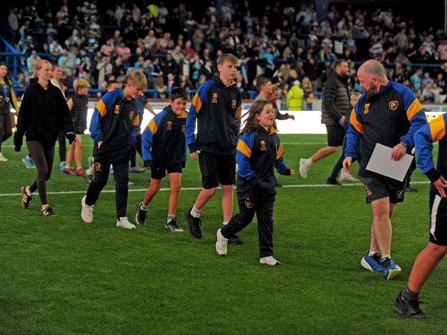 Leeds Rhinos flag wavers enter the pitch before the game.