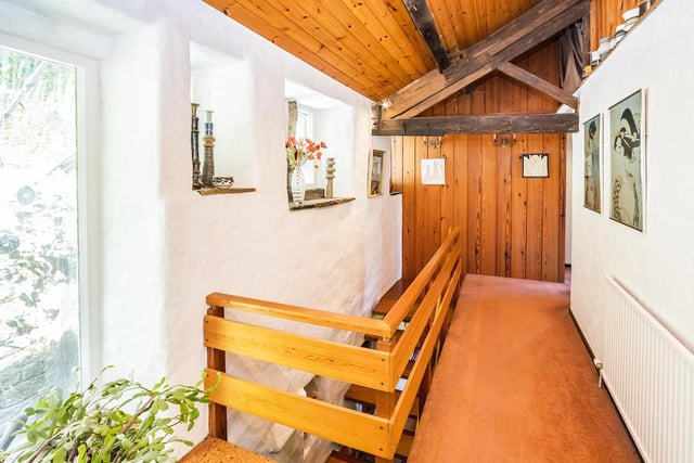 The landing with wooden balustrade leads to four bedrooms.