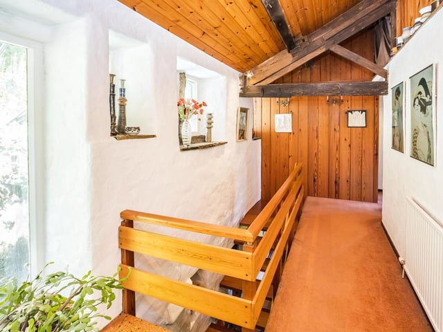 The landing with wooden balustrade leads to four bedrooms.