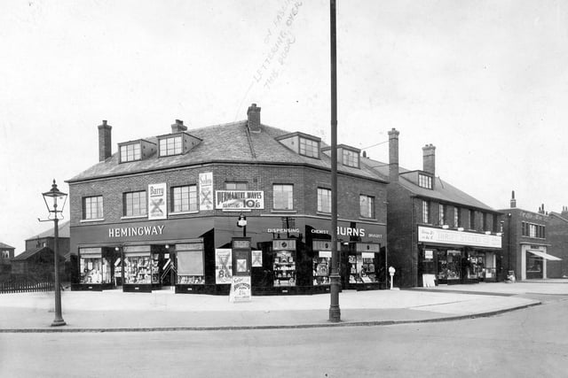 Shops on Dewsbury Road at the junction with Old Lane. The corner building contains three separate business premises. Hemingway seems to have been a sweet shop, tobacconists, draper, dry cleaner and a lending library. Burns was a chemist, whilst upstairs was Barry's Hairdressers. There is a Thrift Store in the next block. Pictured in April 1935.