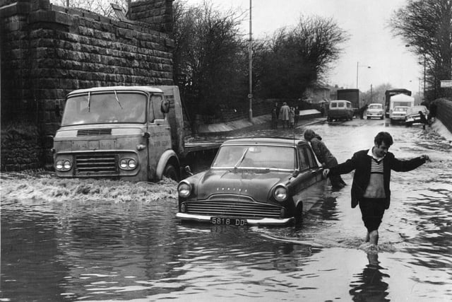 A lorry splashes its way past a car on the Burley in Wharfedale to Guiseley road in March 1960.