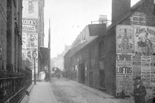 Looking north towards The Headrow in September 1898. Building on left with railings is the Church Institute on the junction with Albion Place. This was opened in 1868. It is now Albion Court and La Senza. Advertising posters on wall include The Santa Cruz Lime Juice Company, Army and Navy Metal polish, Theatre poster for New Empire Palace Theatre has Cissie Loftus, Harry Ford and a dog orchestra all appearing.