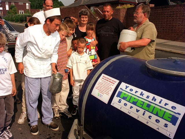 Staff at Woodhouse Community Centre and residents collect water supplies from a bowser in July 1996.