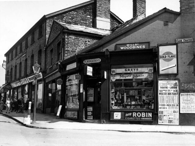 Tobacconists B. Murgatroyd on the corner of Town Street and Carr Crofts in May 1955. Advertisements for various tobaccos in the window and adverts for the Empire theatre on the wall. Progress Stores is also visible.