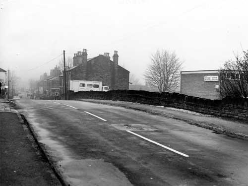 Looking north along Street Lane, showing Gildersome Liberal Club on the right. In the centre, a van belonging to the 4th Morley Gildersome Scout Group is parked beside no. 5 Street Lane. Shops can be seen further along the road. Pictured in February 1980.
