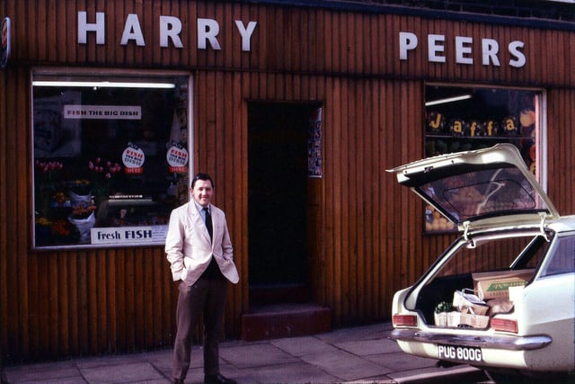 Harry Peers greengrocers shop on Town Street at Moor Top. In this view the owner is outside the shop with a car, registration PUG 800G, parked to the right. The shop also sells fish.