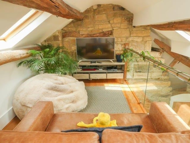 To the ground floor, a wonderful open plan living space incorporates a living, dining and kitchen area. The living area has a lovely recessed fireplace with a log burning stove, Yorkshire stone flooring, under stairs storage cupboard and stairs leading to the first floor.