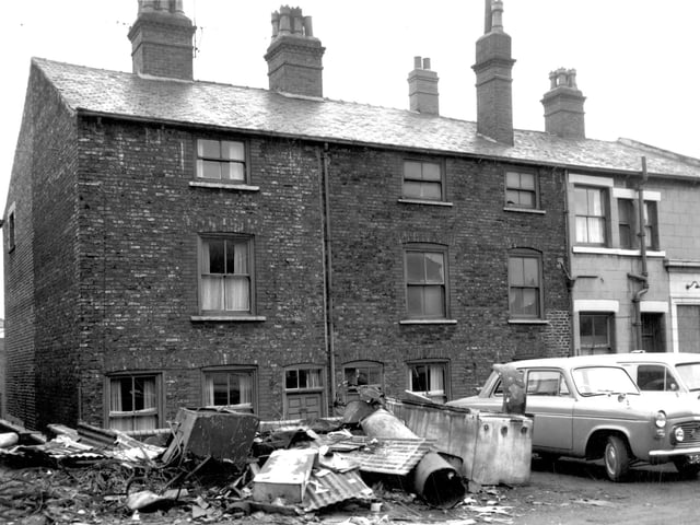 This view looks across Boshell's Place off Skinner Lane in September 1964. Numbers 71 and 73 Skinner Lane can be seen in the background with the cement rendered side of the Plasterer's Arms public house on the right.