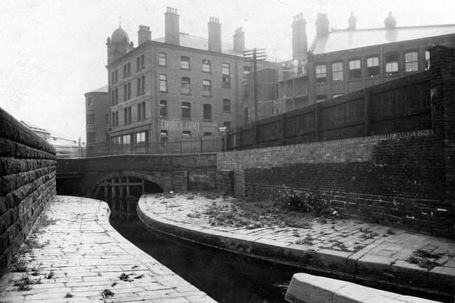 Timble Beck prior to work on covering it. In the background is the Church Army Lodging Home at the junction of The Calls, East Street, and Crown Point Road. Pictured in August 1936.
