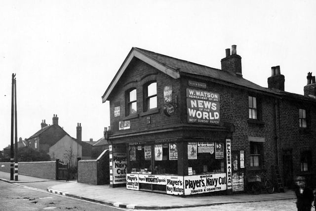 W. Watson newsagents on Town Street by the junction with Silver Street in August 1942. A boy in the foreground looks at the camera.