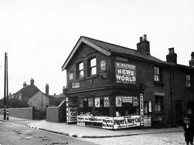 W. Watson newsagents on Town Street by the junction with Silver Street in August 1942. A boy in the foreground looks at the camera.
