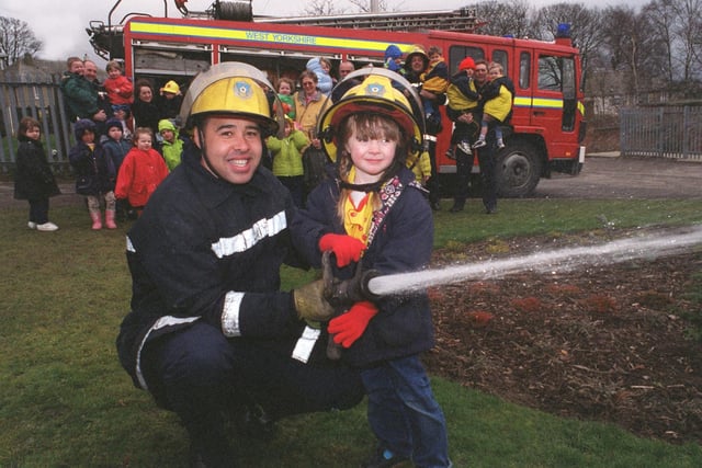 Fire crews from Cookridge Fire Station visited Iveson Primary School to talk to pupils about the dangers of fire in February 1999. Firefighter Stephen Ebanks shows pupil Grace Oliver how to use a hose .